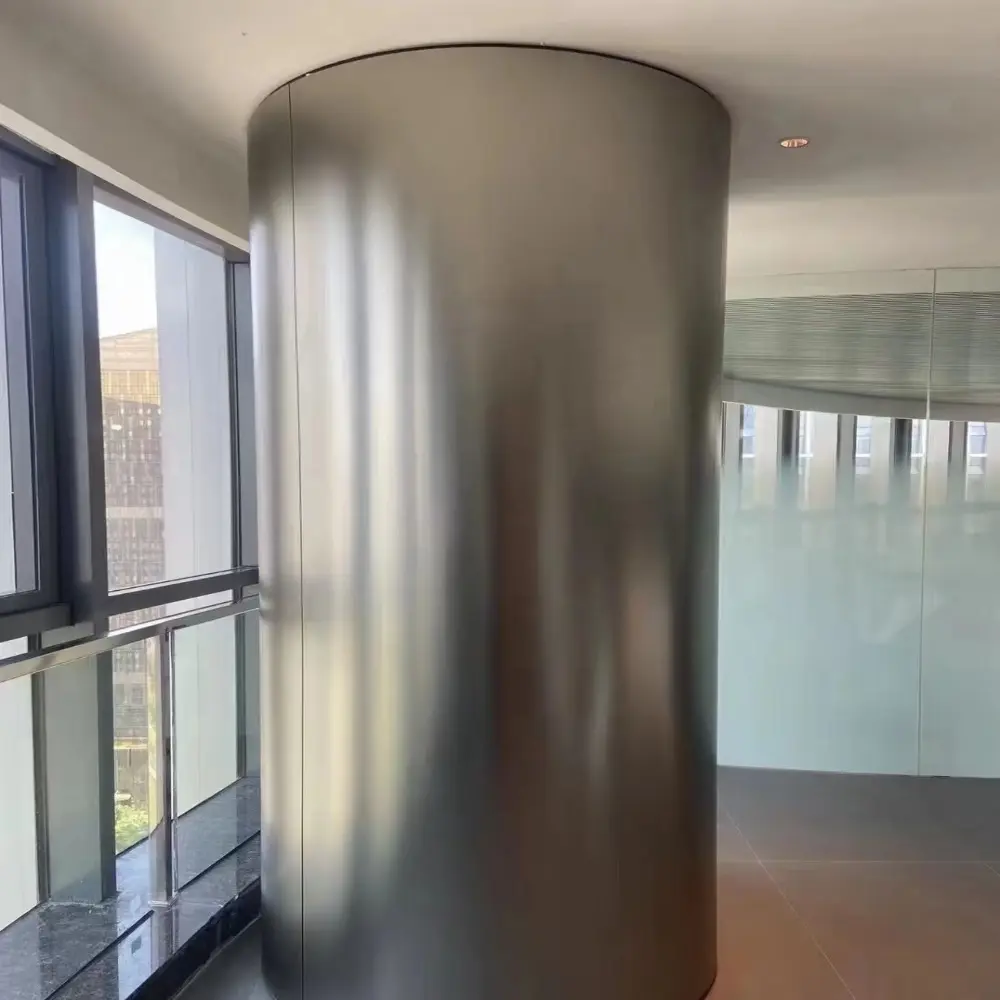 Flexible bendable metal wall panel seamlessly wrapping a circular column in a modern building interior.