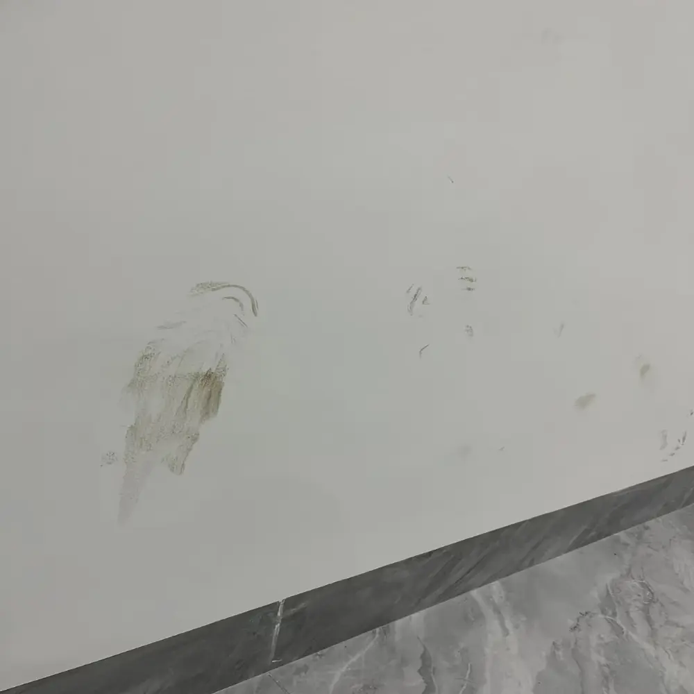 Stained and scuffed white painted wall in a high-traffic corridor