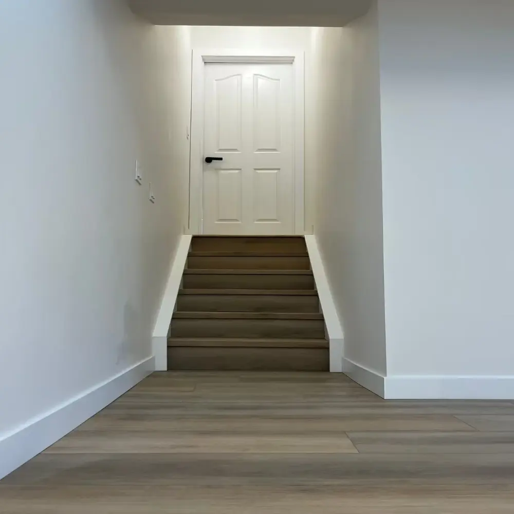 Transición perfecta del piso SPC a las escaleras a juego en un proyecto de sótano.